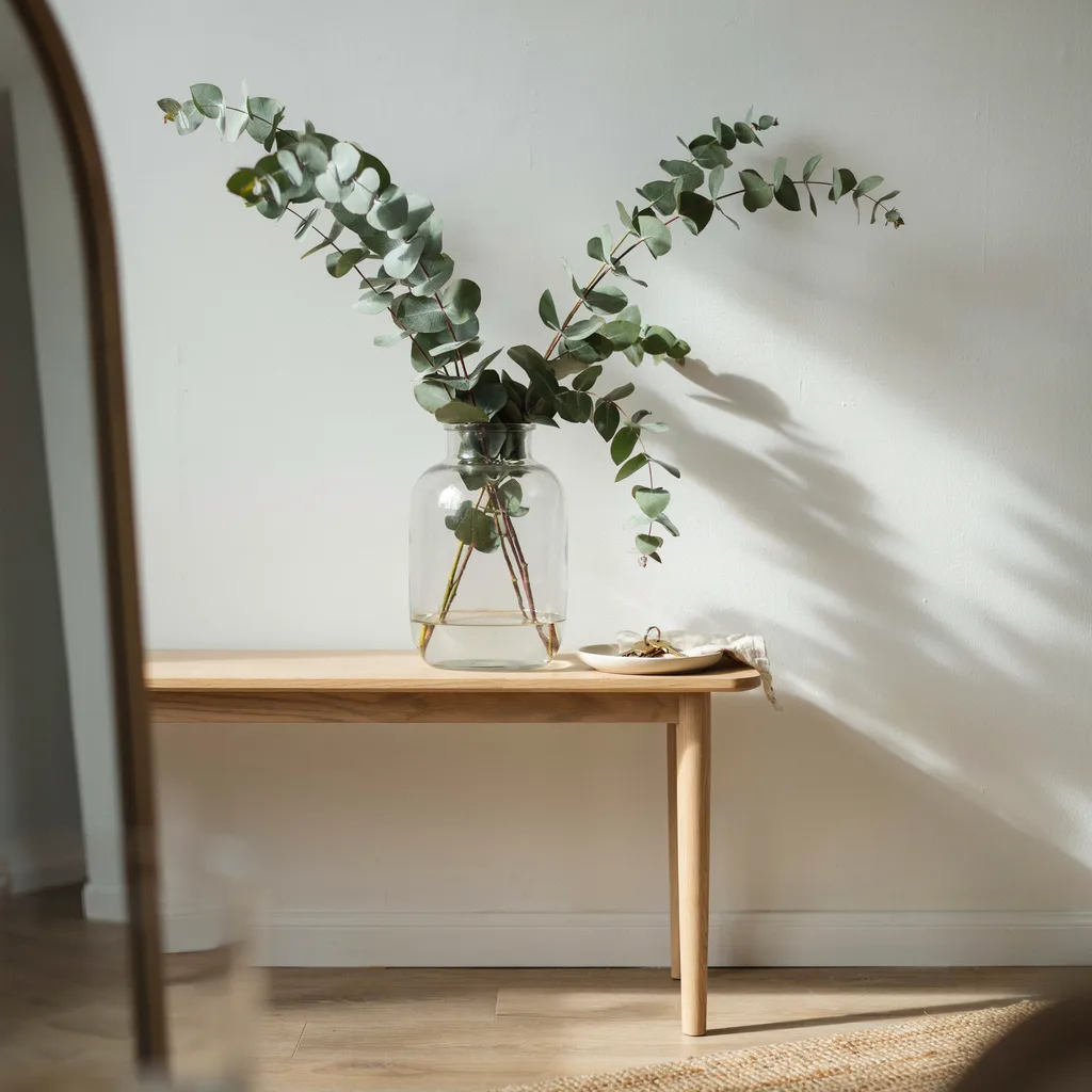 Oversized glass jar with eucalyptus branches on console table entryway decor