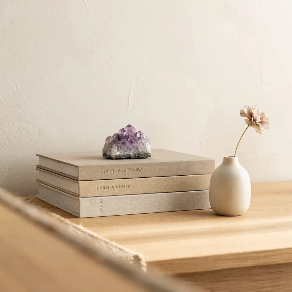 Stacked linen bound design books on console table with crystal decor