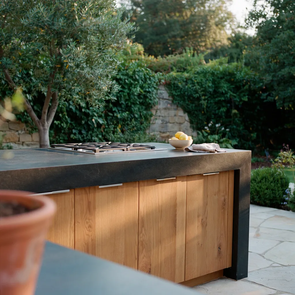 Absolute black honed granite waterfall island with cedar cabinet fronts in outdoor kitchen