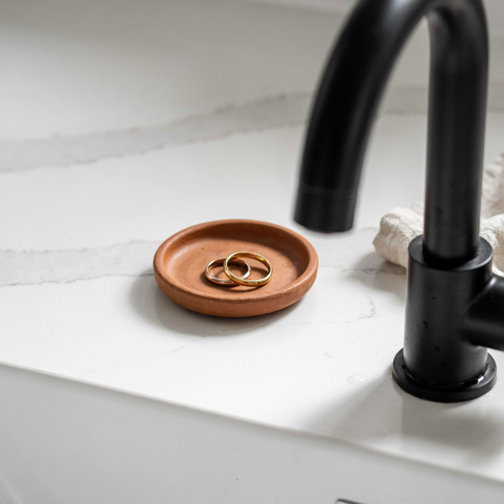 Terracotta clay ring dish beside a bathroom faucet
