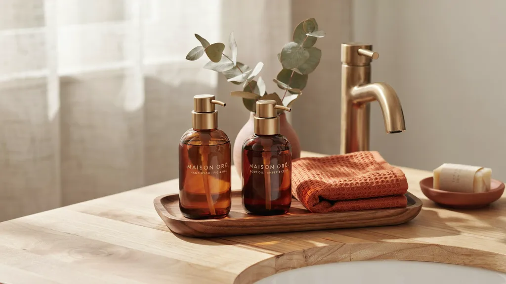 Warm autumn bathroom vanity with wood tray and amber glass